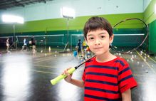 Junge mit Badmintonschläger in einer Sporthalle; Schaltfläche zum Landesprogramm Talentsuche/Talentförderung