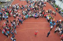 Bild zeigt Drohnenaufnahme von einer Kindermenge auf einem Ballspielfeld; Schaltfläche zu Unterstützungsmaßnahmen des lsb h und der Sportjugend Hessen für Schulen